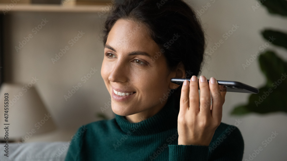 Close up of smiling young Hispanic woman use modern cellphone listen to audio voice record message on gadget. Happy Latin female hold smartphone communicate on loudspeaker. Technology concept. Close up of smiling young Hispanic woman use modern cellphone listen to audio voice record message on gadget. Happy Latin female hold smartphone communicate on loudspeaker. Technology concept.