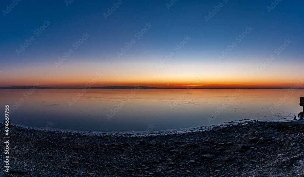 Obraz premium A crimson sunset on the bank of the Volga River on a December evening on the city waterfront!