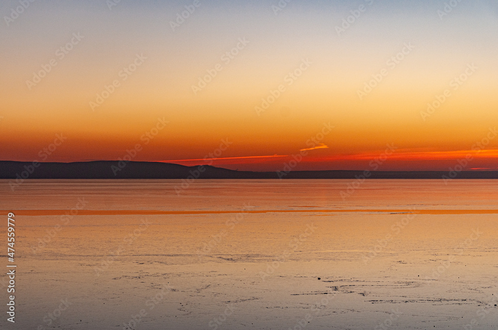 Naklejka premium A crimson sunset on the bank of the Volga River on a December evening on the city waterfront!