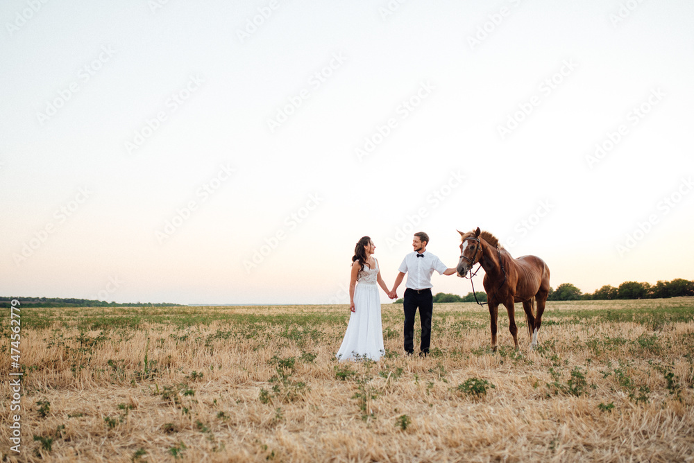 the bride in a white dress and the groom in a white shirt on a walk the bride in a white dress and the groom in a white shirt on a walk