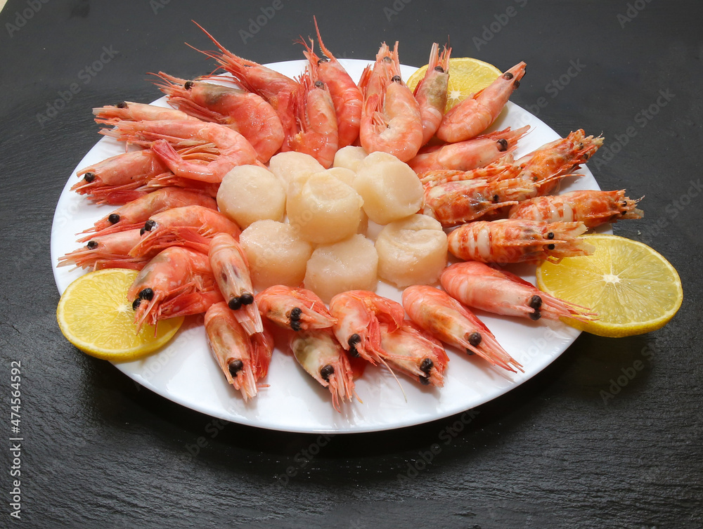 there are scallops, shrimp and lemons on the plate