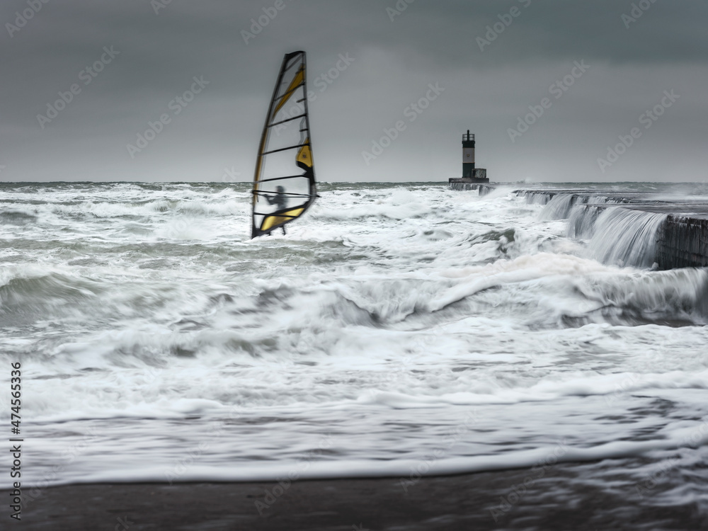 alone wind surfer in waves in storm weather on Black sea in Ukraine alone wind surfer in waves in storm weather on Black sea in Ukraine