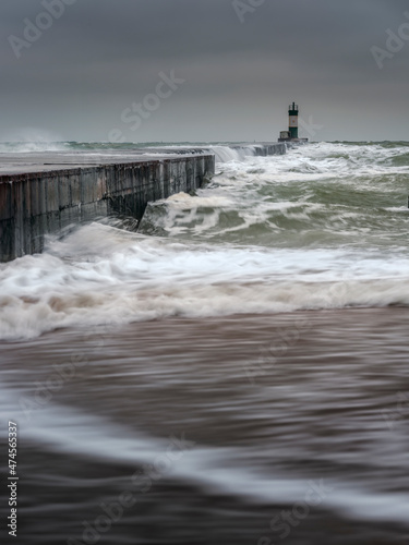 view to pier and landscape in waves and dramatic sky