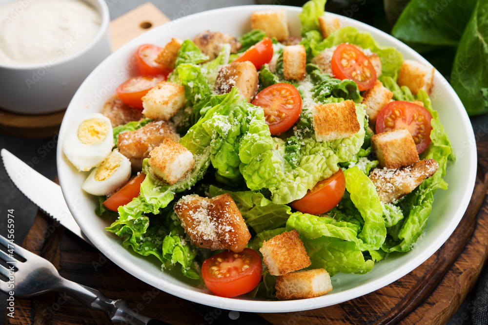 Caesar salad with chicken fillet, cherry tomatoes and croutons, traditional Italian food