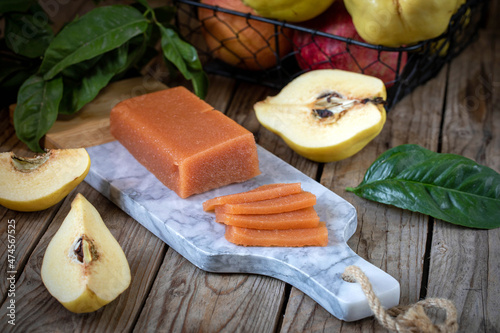 Quince marmalade, with commbert cheese, on a marble board with quince pieces. photo