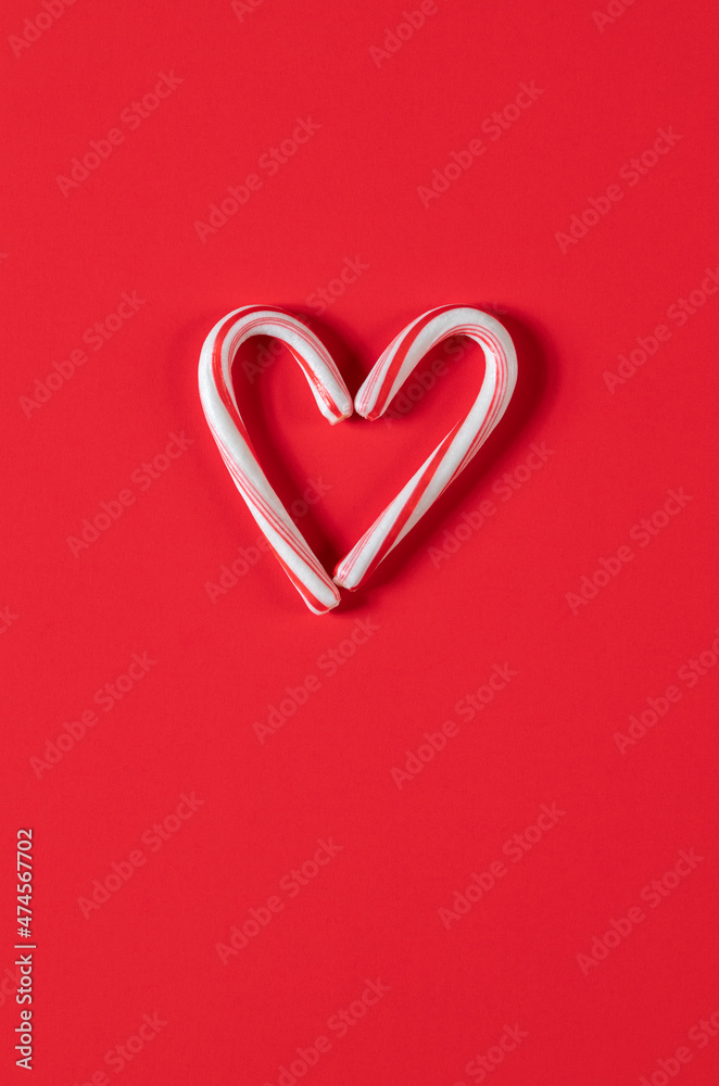 Candy canes in the shape of a heart on a red background