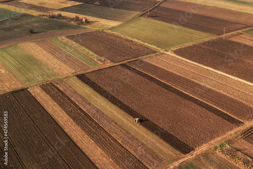 Fotografie, Obraz Aerial view of farmland field tillage with tractor