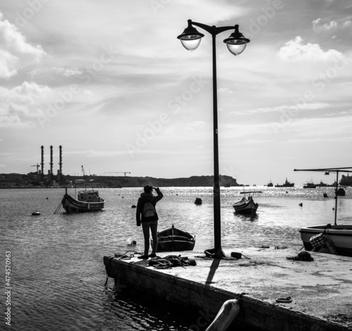 Early morning on the Marsaxlokk waterfront. View of the sea and boats Luzza. Malta. Black and white. photo