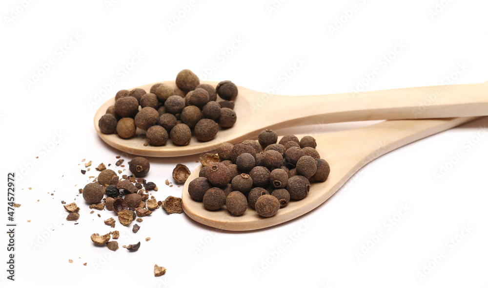 Allspice, pimento spice, Jamaican pepper and shavings in wooden spoon isolated on white Allspice, pimento spice, Jamaican pepper and shavings in wooden spoon isolated on white