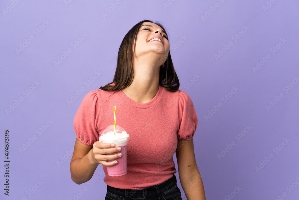 Teenager girl holding a strawberry milkshake laughing Teenager girl holding a strawberry milkshake laughing