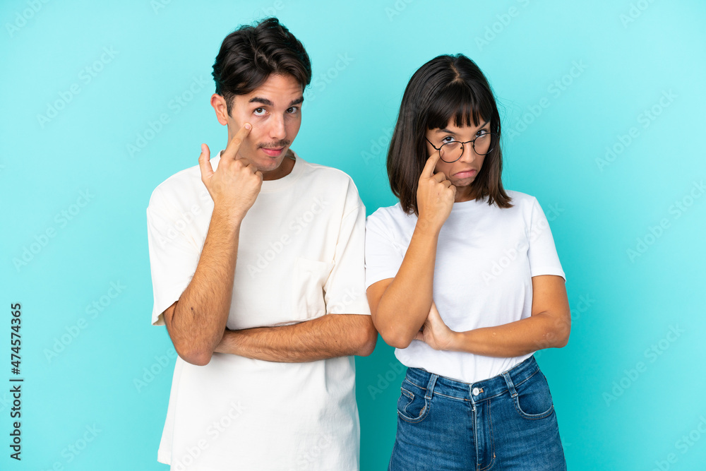 Young mixed race couple isolated on blue background looking to the front Young mixed race couple isolated on blue background looking to the front