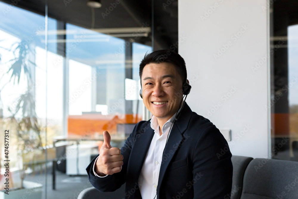 Portrait of a successful Asian businesswoman, man looking at camera and smiling. Call center employee smiling and rejoicing. Portrait of a successful Asian businesswoman, man looking at camera and smiling. Call center employee smiling and rejoicing.