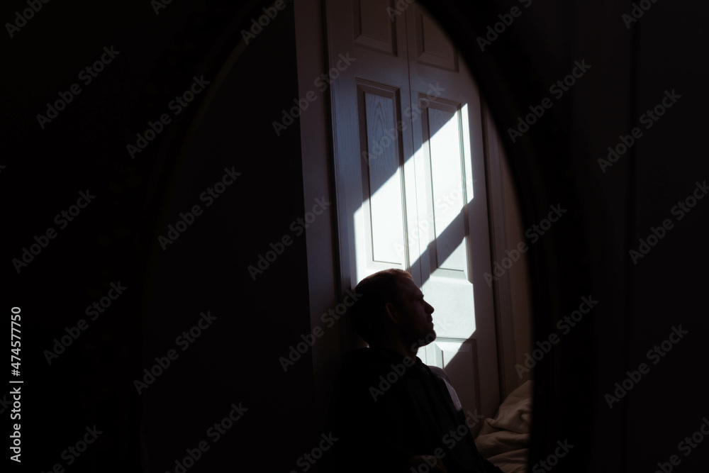 Men in natural light from a window, focus on light and shadow. Men in natural light from a window, focus on light and shadow.