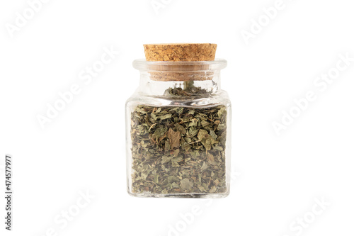 Dried Lemon balm (Melissa officinalis) herb in a glass jar isolated on white background.