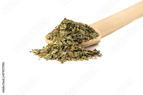 Dried Lemon balm (Melissa officinalis) herb on wooden spoon isolated on white background.
