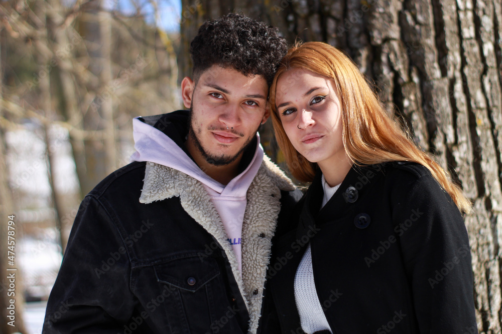 portrait of young interracial couple looking at camera, natural horizontal background portrait of young interracial couple looking at camera, natural horizontal background