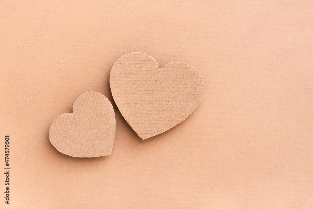Dating concept. Two cardboard hearts together on a beige background. Top view. Valentine's Day Dating concept. Two cardboard hearts together on a beige background. Top view. Valentine's Day