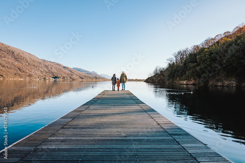 Father, mother and daughter on a pier on Lake Mergozzo