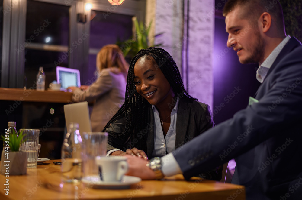 Two business people having a meeting in a cafe while using a laptop