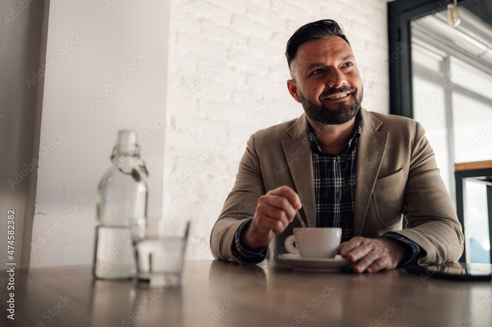 Handsome businessman drinking coffee in a cafe Handsome businessman drinking coffee in a cafe