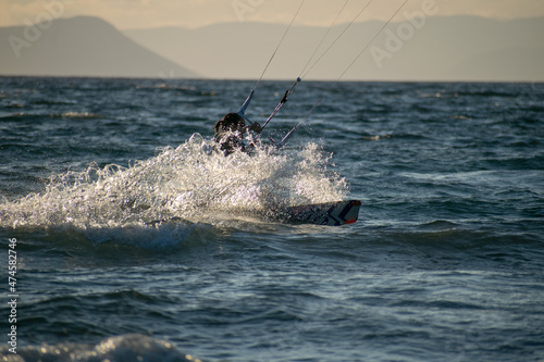 Woman kitesurfer athlete splashes on sea waves © Haris Photography
