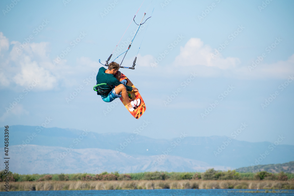 Kitesurfer athlete doing double backroll on air Kitesurfer athlete doing double backroll on air