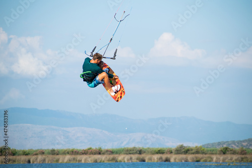 Kitesurfer athlete doing double backroll on air