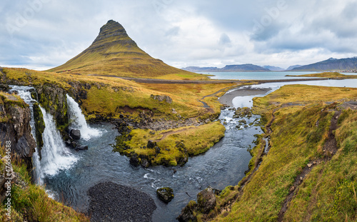 Famous picturesque Kirkjufell mountain and Kirkjufellsfoss waterfall next to Grundarfjörður at West Iceland autumn view.