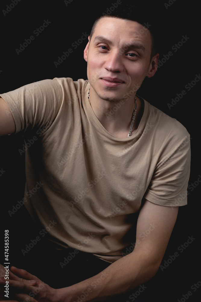 Handsome guy posing in studio on isolated black background. Studio portrait with one light source. Handsome guy posing in studio on isolated black background. Studio portrait with one light source.