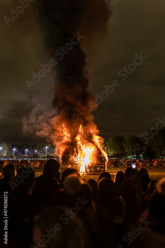 Bonfire organised during the new year´s eve festivities in a public park with a lot of people gathering around the fire celebrating