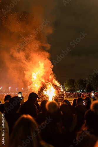 Photo of a bonfire organised during the new year's eve festivities with people out of focus gathering around the fire