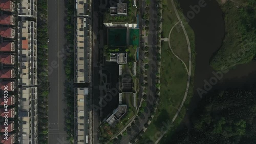 Top down aerial view of ultra modern lakeside housing and apartment development on a sunny day with park, green space, bridges and new architecture. View of exclusive villas. photo