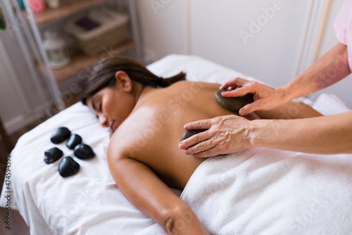 Professional therapist giving a hot stone massage