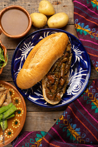 Mexican romeritos sandwich with mole sauce and shrimp on a wooden background photo