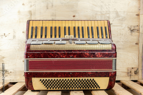 Old red accordion covered with dust