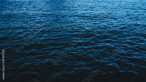 The deep serene sea. Dark blue ocean waves background. Calm water surface. Nature backdrop. © Win Nondakowit