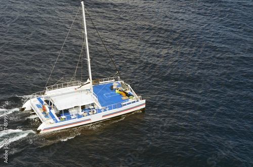 White luxury sail catamaran running under auxiliary power. © Wimbledon