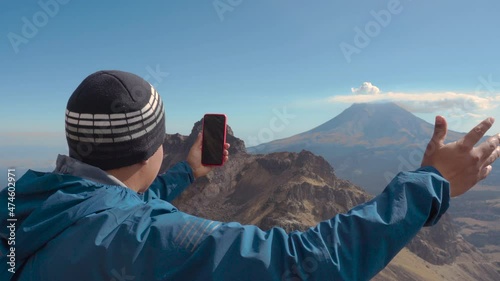 Handsome man taking a selfie on a trip in popocatepetl volcano photo