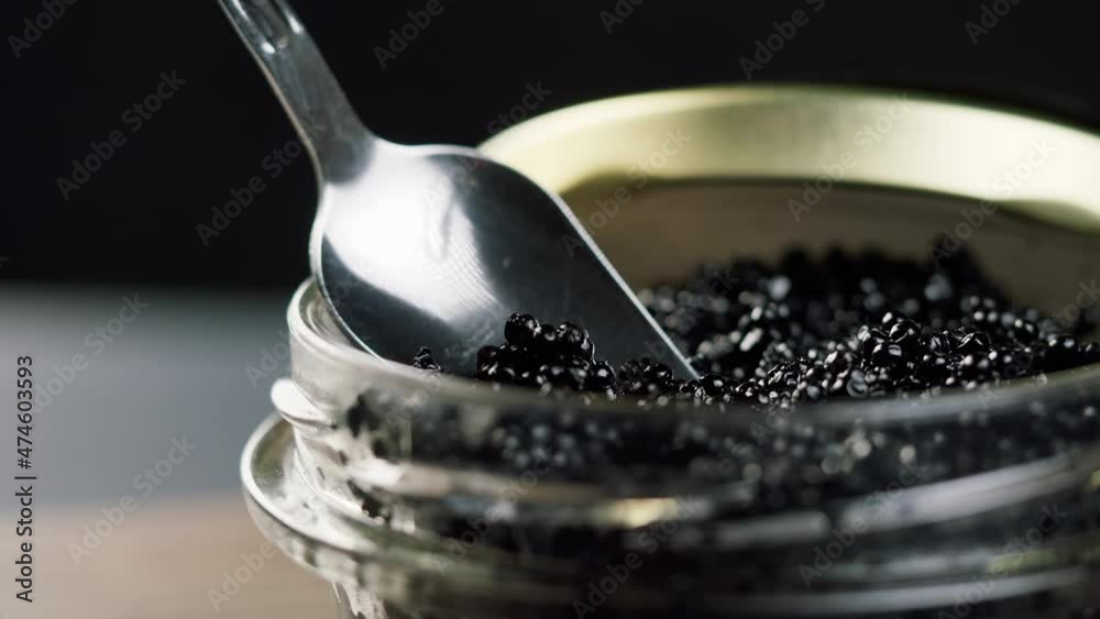 Black caviar close-up. Beluga sturgeon salted roe in glass bowl. Raw seafood. Luxury delicacy food. Delicious and tasty fish products. Russian cuisine. Festive dinner. Black caviar close-up. Beluga sturgeon salted roe in glass bowl. Raw seafood. Luxury delicacy food. Delicious and tasty fish products. Russian cuisine. Festive dinner.