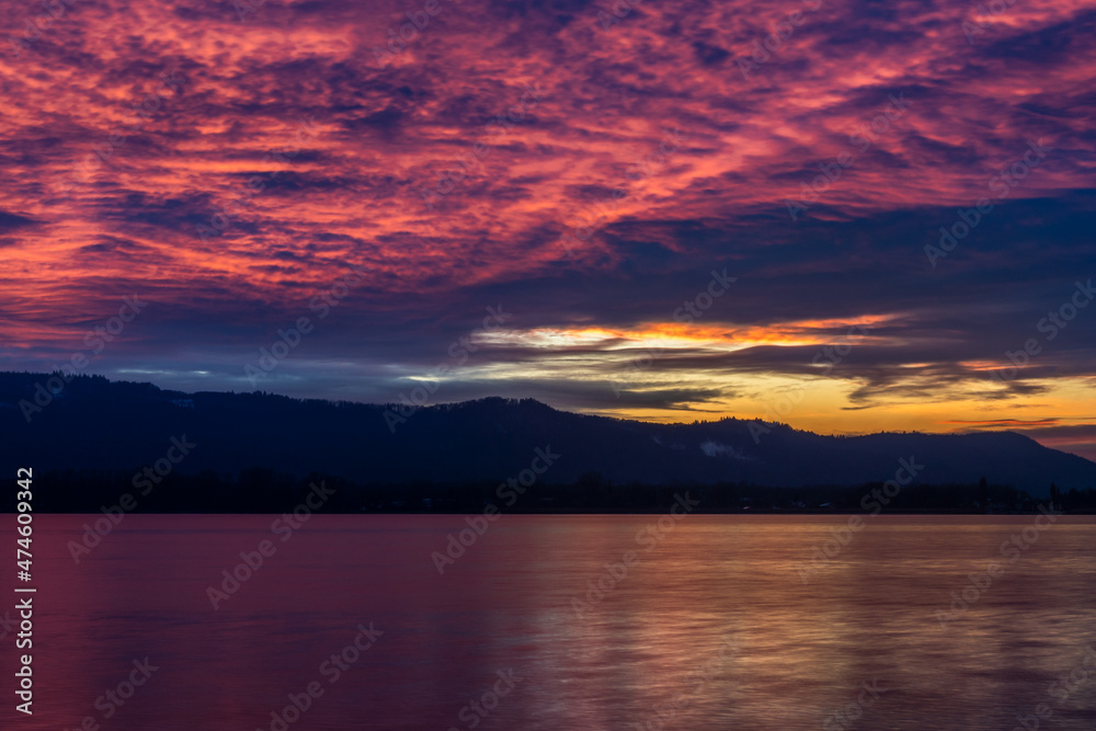 Sonnenuntergang mit kraftvollen roten Wolken am Himmel am schönen Bodensee 