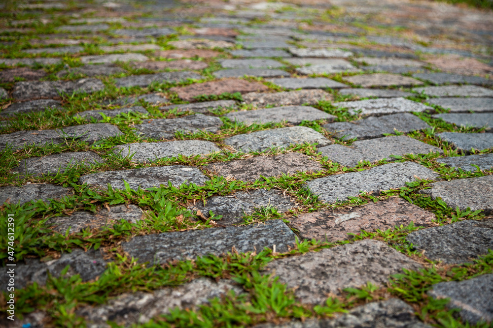 Cobblestone street texture. Regular shapes of cobblestone road, abstract background of old cobblestone pavement close-up.
