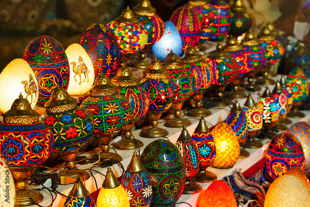 In the bazaar, there are Middle Eastern lambas in various colors and sizes. Bright traditional Arabic and Turkish lanterns made of metal and glass, inlaid with mosaic details in different colors.