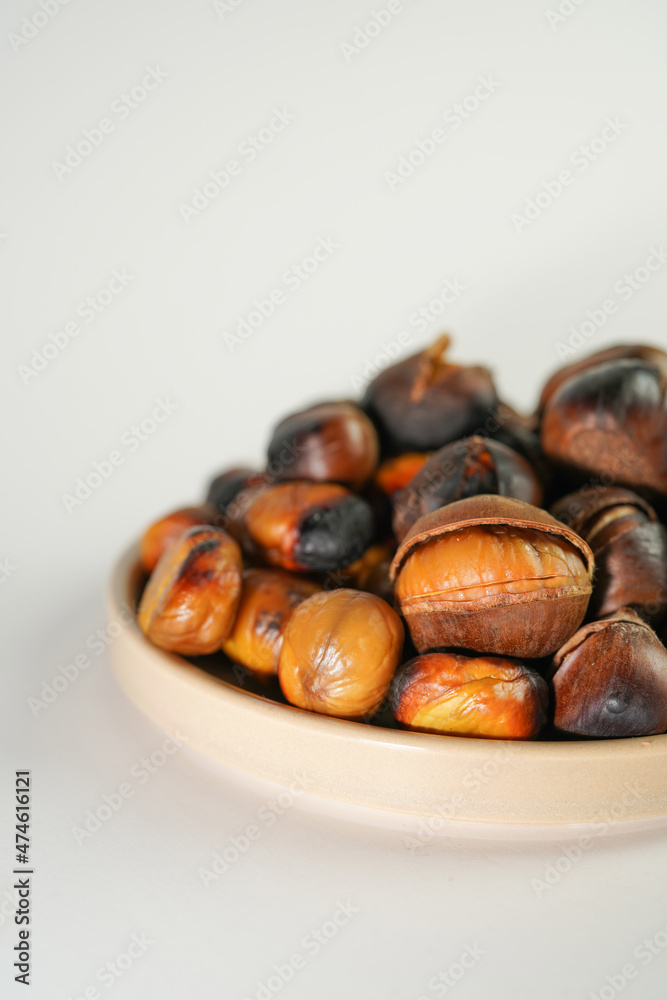 Obraz premium roasted chestnuts on a white background, winter