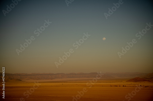 A moon visible after sunset seen from Elim Dune  Namib Desert  Namibia