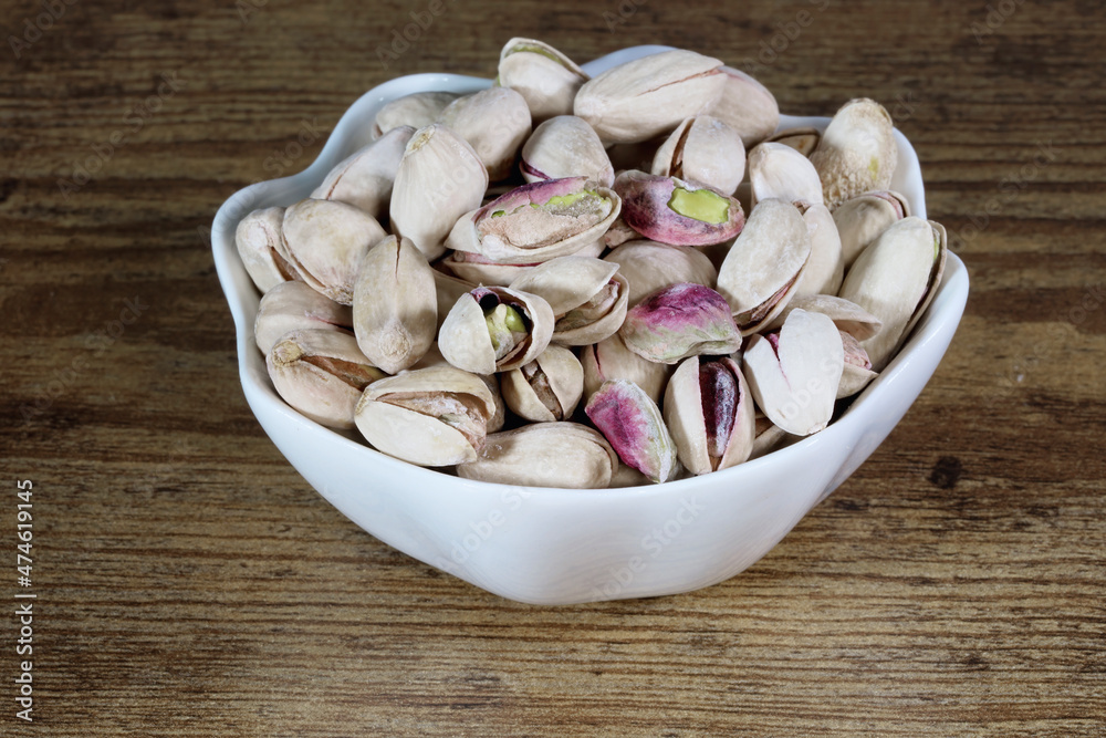 pistachio nuts in a small white bowl pistachio nuts in a small white bowl