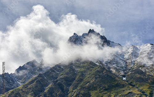 Clouds around mountain peak on summer day