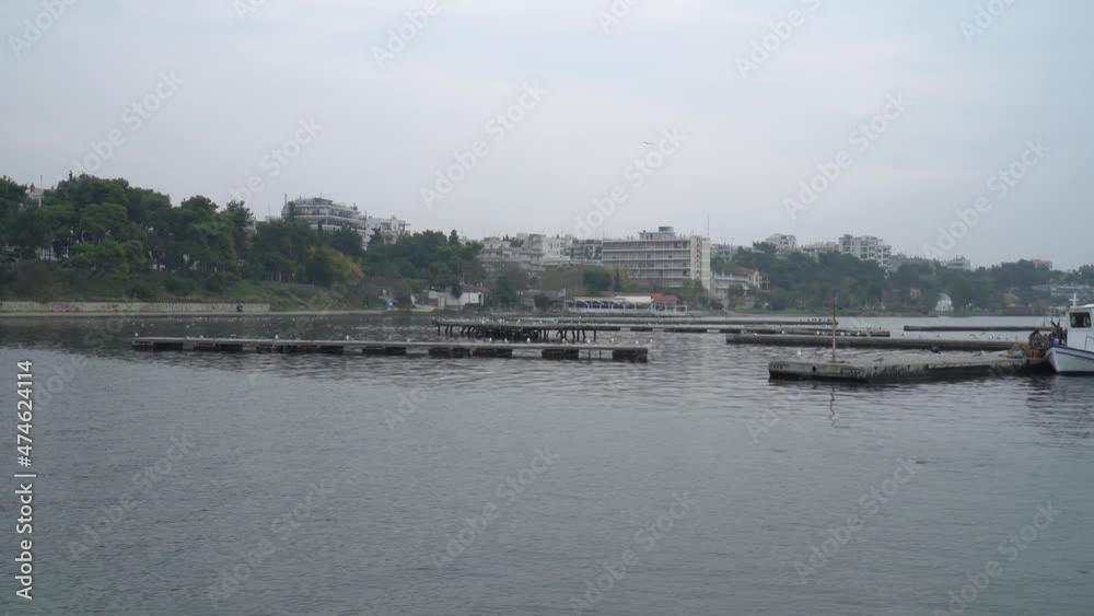 Parallax shot of seagulls flying over the sea and a moored boat