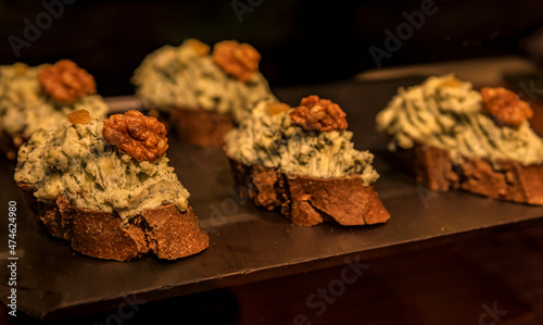 Valokuva Traditional Spanish pintxos of crumbled goat cheese with walnut on display in a