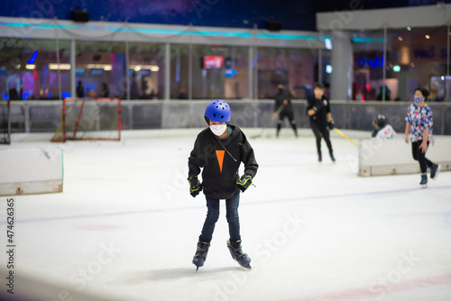 Asian teenager boy play ice skate indoor