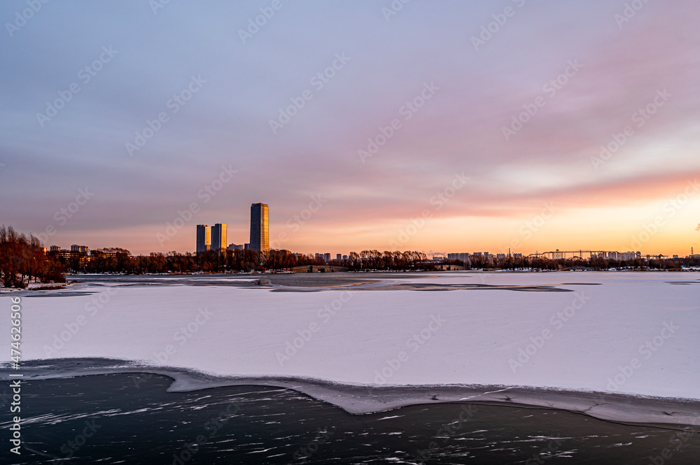 Winter scenery of the North Lake National Wetland Park in Changchun, China under the sunset
